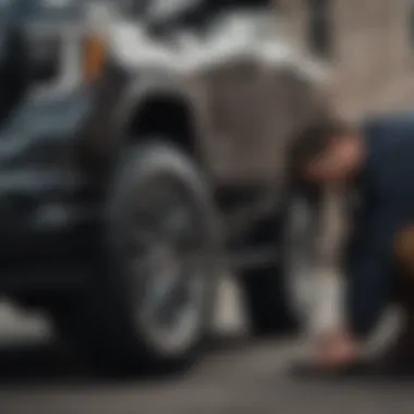 Mechanic checking tire pressure on a GMC Sierra 1500 Denali